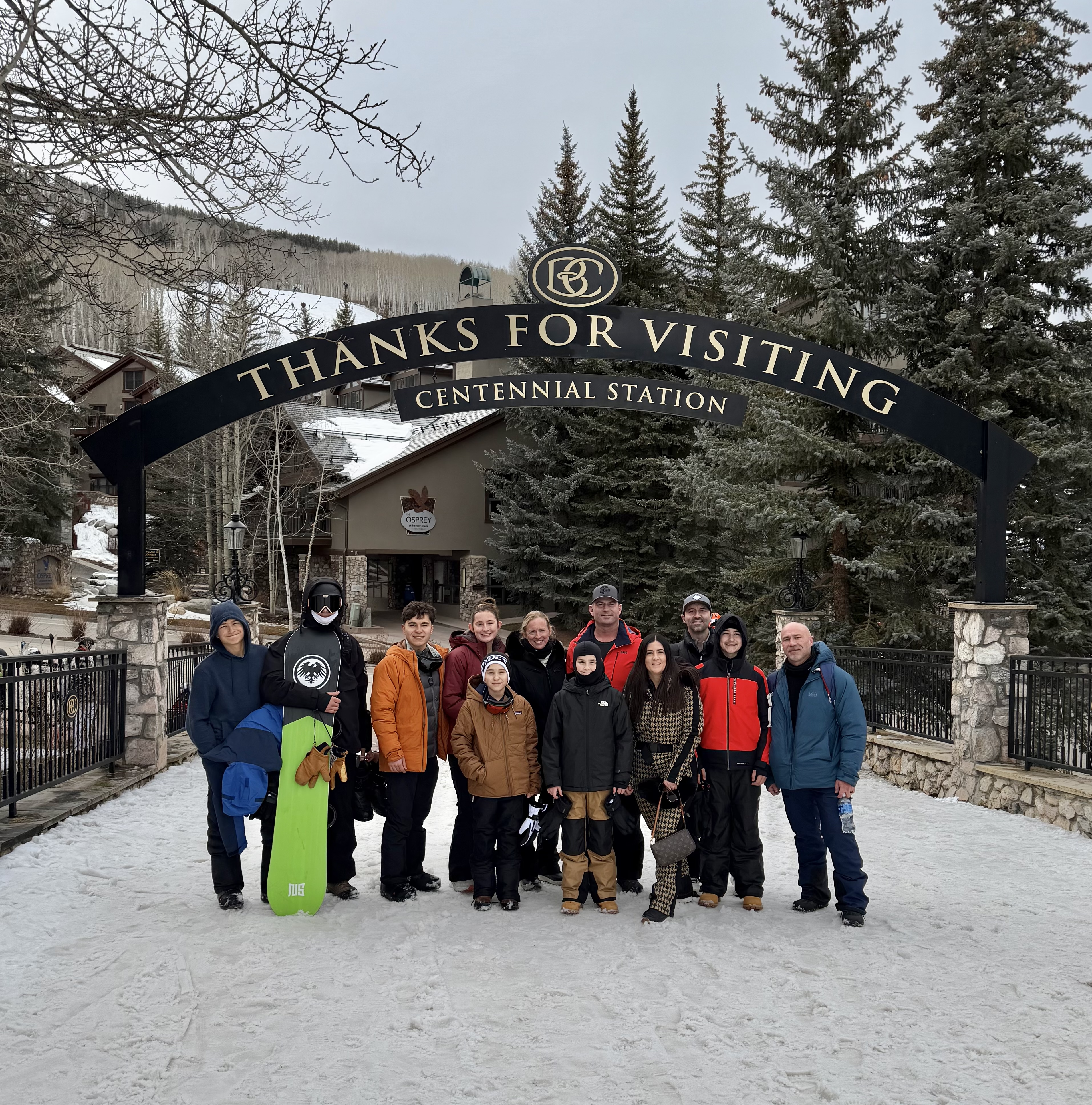 Large group gathered under the Centennial Station thanks for visiting arch